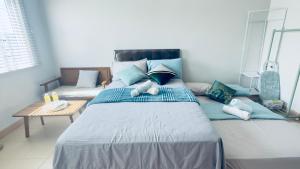 a large bed with blue pillows in a room at Unwind with Peace at Cheer Residences SM Marilao-Philippine Arena in Marilao +50 photos