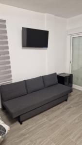 a black couch in a living room with a flat screen tv at Complejo Las Majadillas in Iznájar