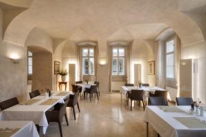 a restaurant with white tables and chairs and windows at Three Storks in Prague +30 photos