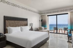 a bedroom with a large bed and a view of the ocean at Hilton Los Cabos in San José del Cabo +110 photos
