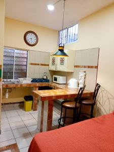 a kitchen with a table and a clock on the wall at Casa Amelia in San Blas +11 photos