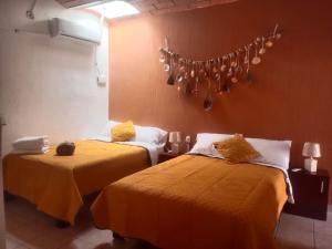two beds in a room with cups on the wall at Casa Amelia in San Blas