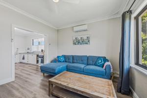 a living room with a blue couch and a table at Cottage on Carson in Geraldton