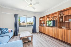 a living room with a blue couch and a tv at Cottage on Carson in Geraldton