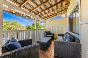 a screened in porch with wicker furniture and windows at Cottage on Carson in Geraldton
