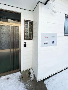 a front door of a building with snow on the ground at 台町Arun別邸 in Abashiri