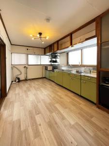an empty kitchen with green cabinets and wooden floors at 台町Arun別邸 in Abashiri