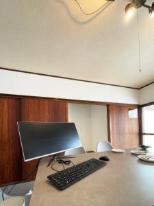 a computer monitor and a keyboard and mouse on a desk at 台町Arun別邸 in Abashiri