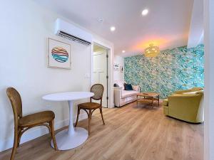 a living room with a table and chairs and a couch at Get Seaduced by this 1 bed 1 bath charmer steps to beach and Bridge St in Bradenton Beach