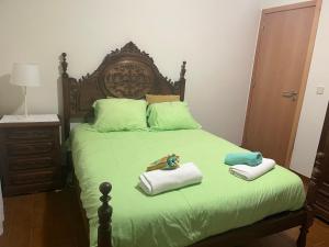 a bedroom with a bed with two towels on it at Casa da Ramada - Water SPA Tank with running natural spring water - by Bedzy in Braga