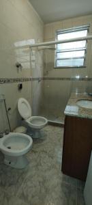 a bathroom with two toilets and a shower and a sink at Bem te vi in Niterói