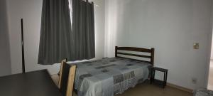 a bedroom with a bed and a table and a window at Bem te vi in Niterói