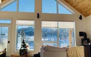a living room with large windows and a couch at NOvO Chalet in Saint-David-de-Falardeau
