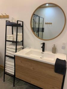a bathroom with a sink and a mirror and towels at NOvO Chalet in Saint-David-de-Falardeau