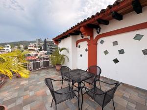 un patio con tavolo e sedie su un balcone di Hotel Mocali a Puerto Vallarta