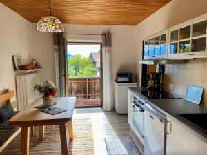 a kitchen with a table and a view of a porch at Weberhof in Samerberg