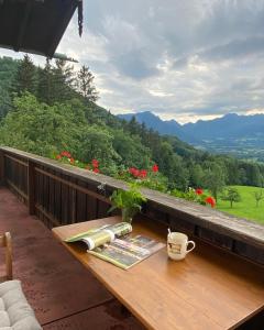 a table on a balcony with a book and a coffee cup at Weberhof in Samerberg +17 photos