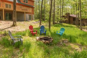 four chairs sitting around a fire in a yard at Lighthearted Lodge by Railey Vacations in Swanton