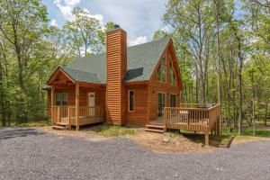 a log cabin in the woods with a porch at Lighthearted Lodge by Railey Vacations in Swanton