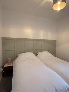 a bedroom with two white beds and a lamp at Flat in Lundin Links in Lundin Links