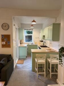 a kitchen with green cabinets and a table and chairs at Flat in Lundin Links in Lundin Links