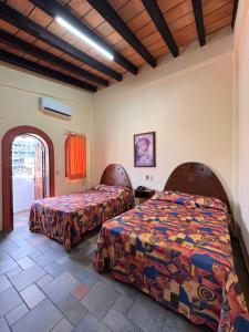 una camera da letto con due letti in una stanza di Hotel Mocali a Puerto Vallarta
