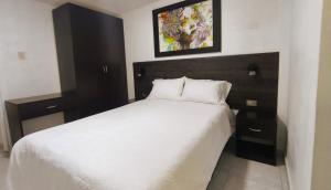 a bedroom with a large white bed and two night stands at mini departamento Andahuaylas in Andahuaylas