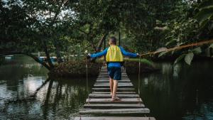 a person walking across a bridge in the water at WISIRARE ECOLODGE - Luxury experience in Yopal +15 photos