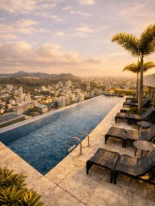 a pool on the roof of a building with benches at Palazzo Torquetti in Belo Horizonte