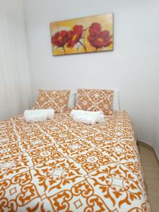 a bed with two pillows and a painting on the wall at HOME CENTRO B max 5 personas HOME CENTRO A max 6 personas in Marchena +26 photos