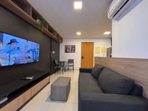 a living room with a couch and a flat screen tv at Apart St Bueno Ar, Cozinha, Garagem Próx Órion in Goiânia