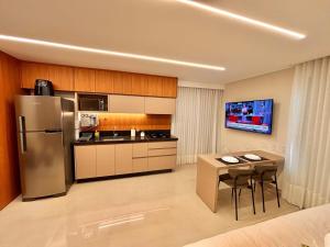 a kitchen with a refrigerator and a table with chairs at Apart St Bueno SuperKing Ar, Cozinha, Vaga in Goiânia