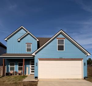 a blue house with a white garage at Wanderlust House in Shreveport
