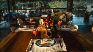 a wooden table with plates of food and wine glasses at WISIRARE ECOLODGE - Luxury experience in Yopal