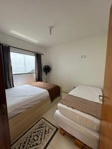a bedroom with two beds and a window at Casinha da Val in Atibaia