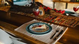 a table with a plate of food and a glass of wine at WISIRARE ECOLODGE - Luxury experience in Yopal