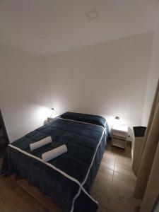 a bedroom with a bed with two pillows on it at Dormi km3 in Comodoro Rivadavia