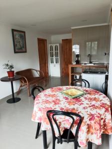 a kitchen with a table with a floral table cloth at Regreso al Encanto in Puyehue