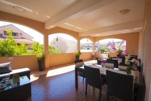 a room with a table and chairs and windows at Apartment Kukljica 8253d in Kukljica