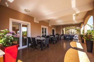 a dining room with tables and chairs and flowers at Apartment Kukljica 8253d in Kukljica +23 photos