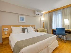 a hotel room with a large bed and a desk at Novotel RJ Santos Dumont in Rio de Janeiro +159 photos