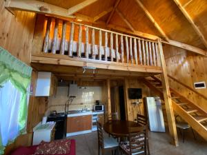 a kitchen and dining room of a log cabin at Cabañas Antonia in Futaleufú