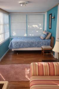 a bedroom with a bed with blue walls and a couch at GpL 424 San Bernardino in North Fort Myers