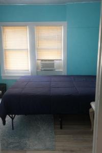 a bedroom with a bed with blue walls and two windows at GpL 424 San Bernardino in North Fort Myers