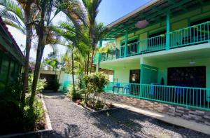 a house with palm trees in front of it at Bohemian Monkey in Cahuita