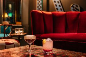 ein Tisch mit zwei Gläsern und einem Getränk darauf in der Unterkunft Ruby Lucy Hotel London by IHG in London + 66 Fotos