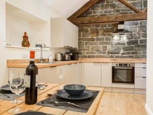 a kitchen with a table with a wine bottle and glasses at Wheelwright Cottage in Clunbury