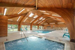 an indoor swimming pool with a wooden ceiling at Ski Harbor #32 by Railey Vacations in McHenry +20 photos