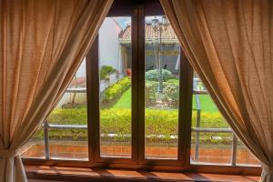 an open window with a view of a garden at SÁ Hotel in Cuenca