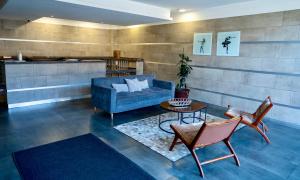 a living room with a blue couch and a table at DEPARTAMENTO ACOGEDOR Y TRANQUILO en Chillán Centro, full equipado, ideal para descansar, Wifi y Estacionamiento in Chillán